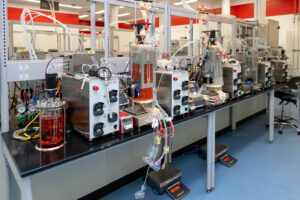A scientist monitors a bioreactor run from a control station at the Bioprocess Design Center, the human-in-the-loop oversight Ram describes as essential before instruments become more autonomous. (Credit: Thermo Fisher Scientific)